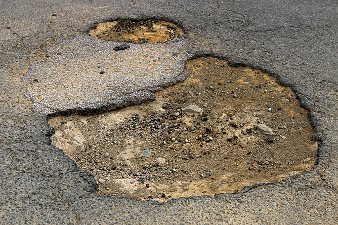 This is the pothole which killed the tire on my rental car. It is significantly deeper than it appears here. Photograph ©2015 by Brian Cohen.