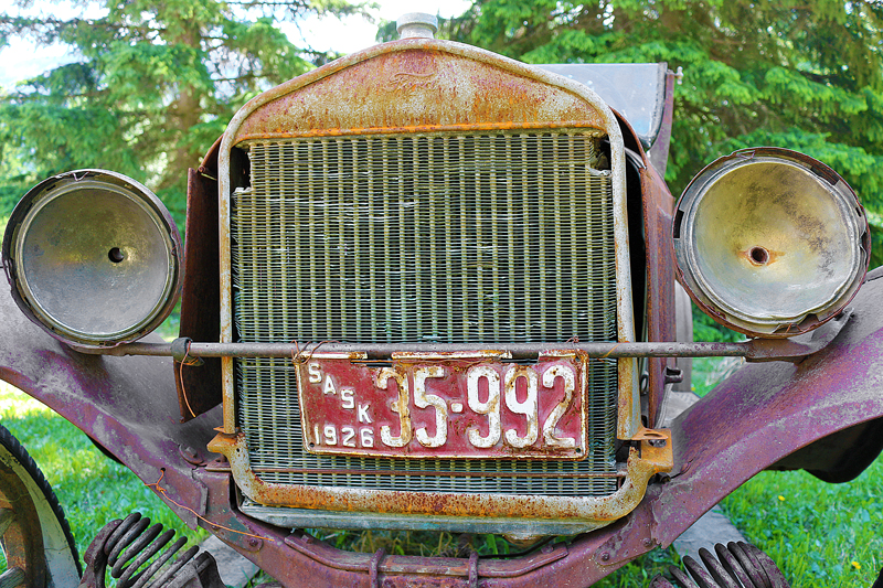 a rusty old car with two headlights