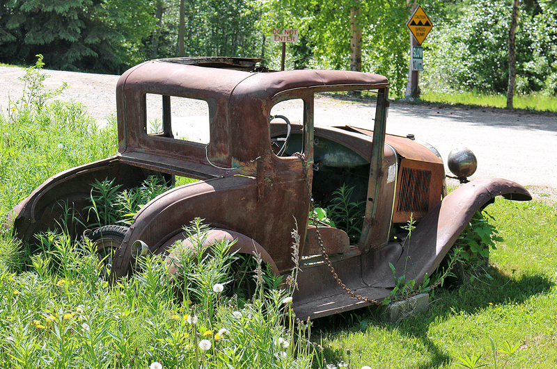 an old rusty car in the grass