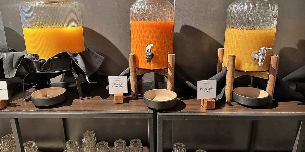 a group of glass jars with orange liquid on a shelf