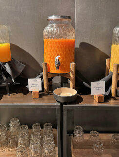 a group of glass jars with orange liquid on a shelf