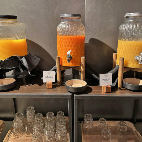 a group of glass jars with orange liquid on a shelf