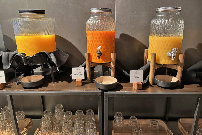 a group of glass jars with orange liquid on a shelf
