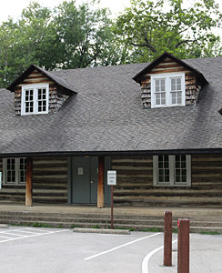 a log cabin with a parking lot