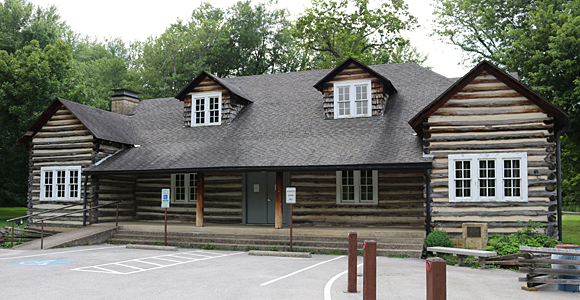 a log cabin with a parking lot