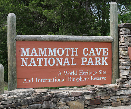 a sign in front of a stone wall