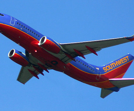 a red and blue airplane in the sky