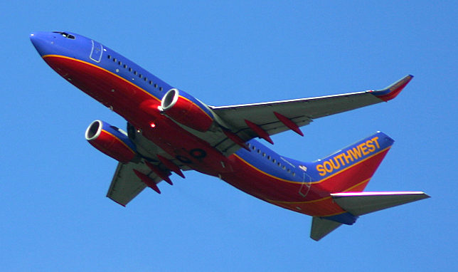 a red and blue airplane in the sky