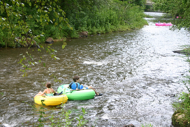 a group of people in tubing on a river