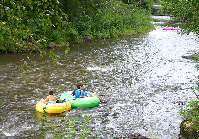 a group of people in tubing on a river