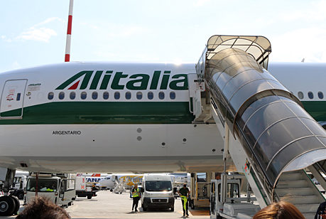 a plane with a staircase and people in the background