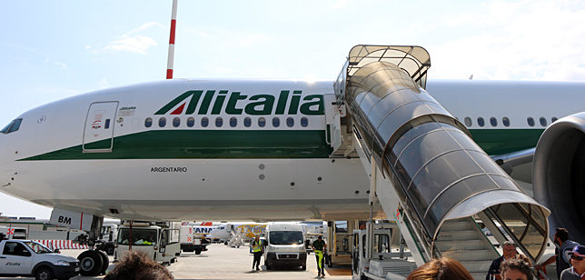 a plane with a staircase and people in the background