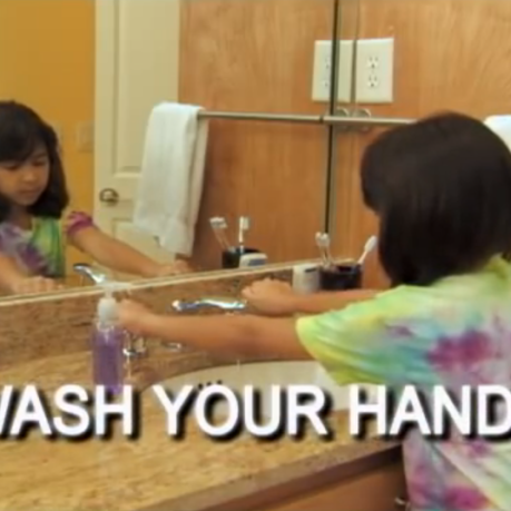 a girl washing her hands in a bathroom