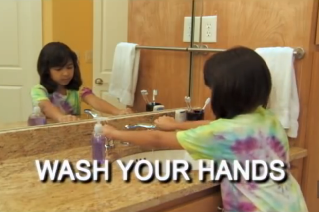 a girl washing her hands in a bathroom