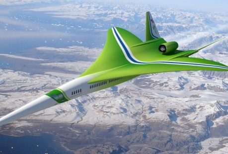 a green airplane flying over mountains