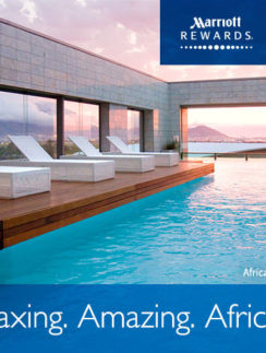 a pool with lounge chairs and a building with a sunset