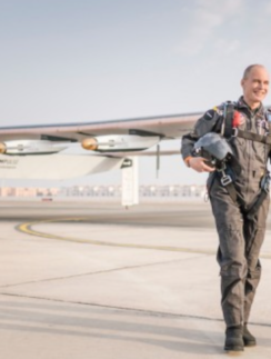 two men in flight gear walking on a runway