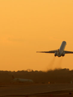 Airplane taking off at sunset