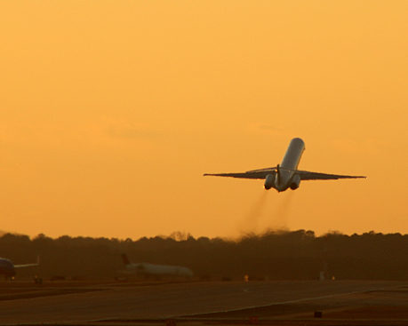 Airplane taking off at sunset