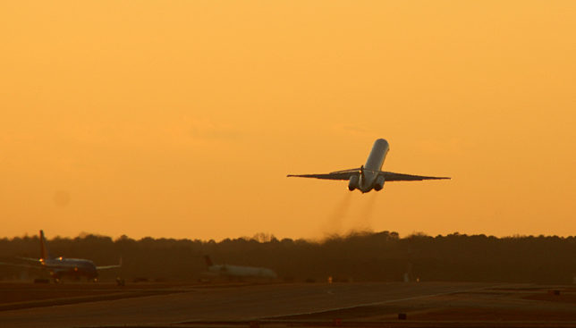 Airplane taking off at sunset