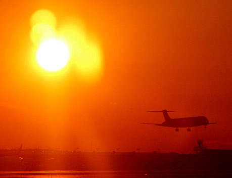 Airplane taking off at sunset
