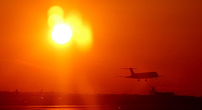 Airplane taking off at sunset