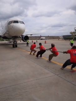 a group of people pulling a plane