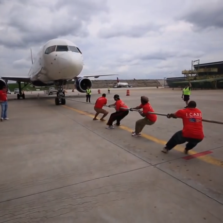 a group of people pulling a plane