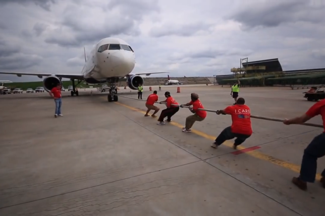 a group of people pulling a plane