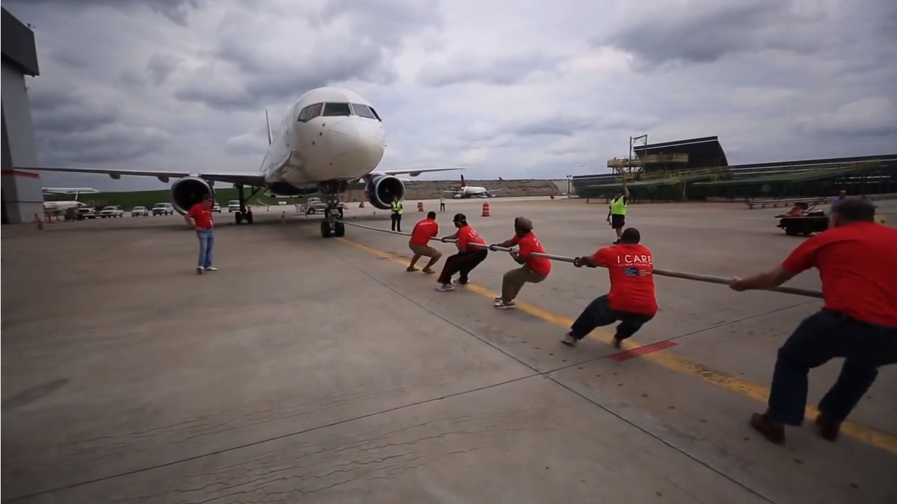 a group of people pulling a plane
