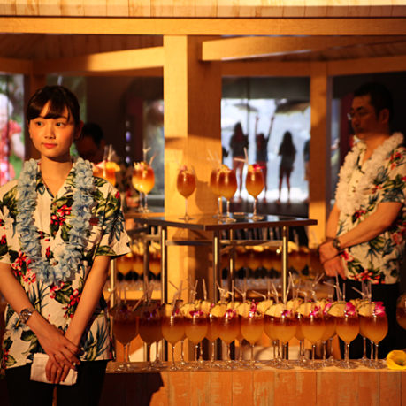 a woman standing in front of a table full of drinks