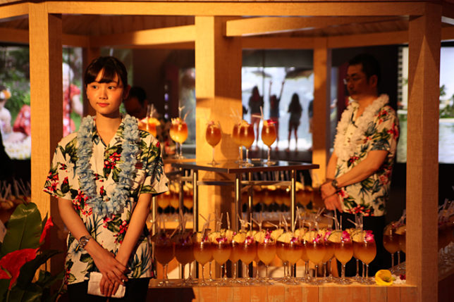 a woman standing in front of a table full of drinks
