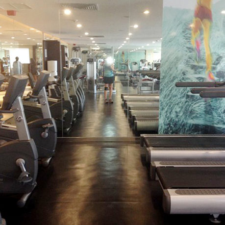 a room with treadmills and a woman in the background