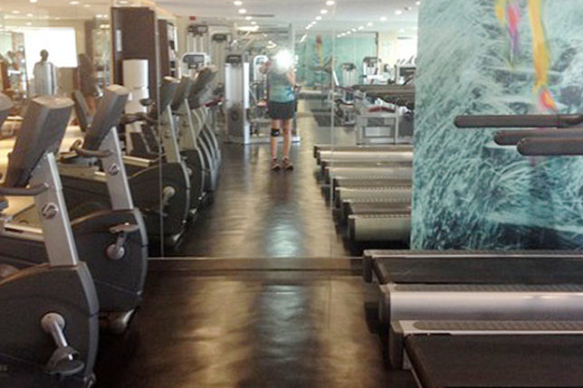 a room with treadmills and a woman in the background