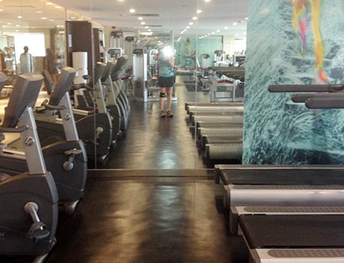 a room with treadmills and a woman in the background