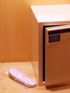a small safe with a keypad and a shoe in a plastic wrap