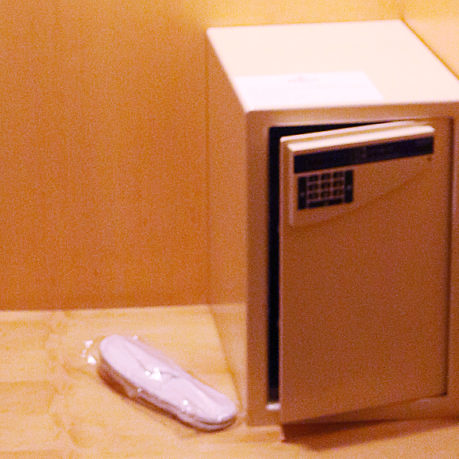 a small safe with a keypad and a shoe in a plastic wrap