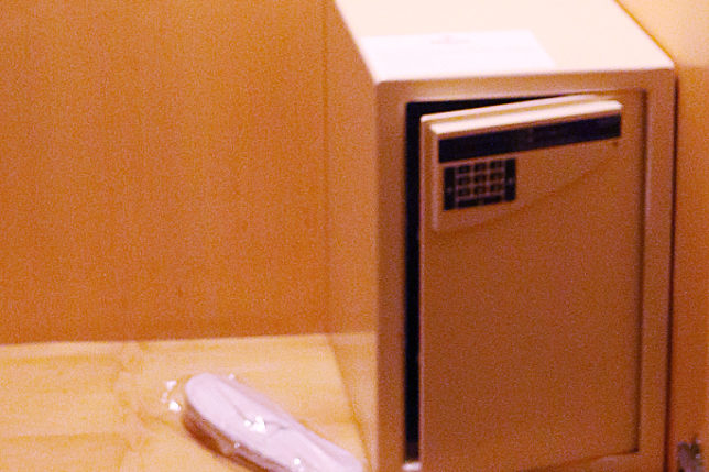 a small safe with a keypad and a shoe in a plastic wrap