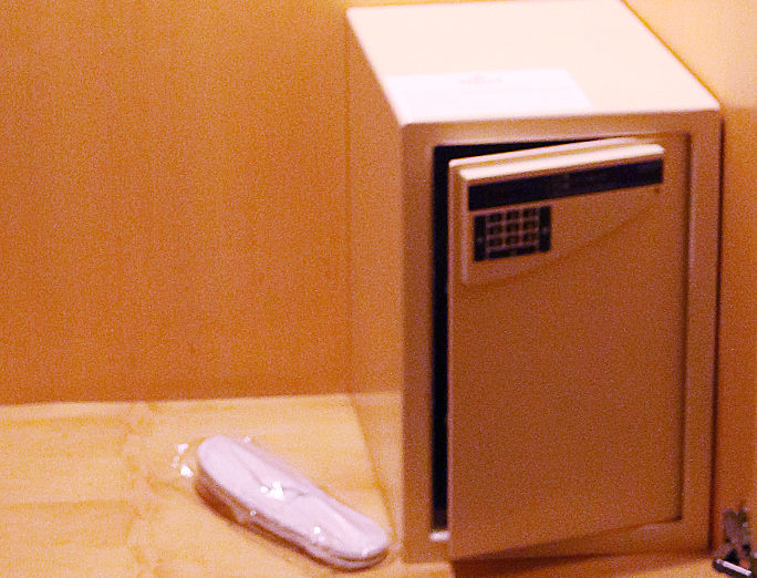 a small safe with a keypad and a shoe in a plastic wrap