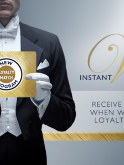 a man in a tuxedo holding a gold sign