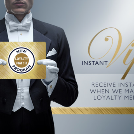 a man in a tuxedo holding a gold sign