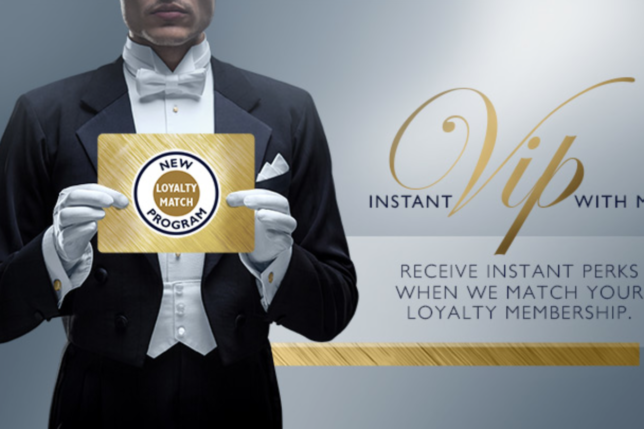 a man in a tuxedo holding a gold sign