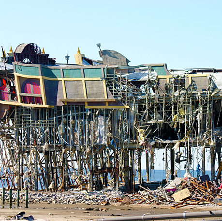 a building with scaffolding and debris on the beach