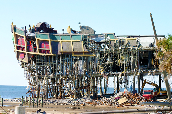 a building with scaffolding and debris on the beach