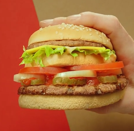 a hand holding a burger