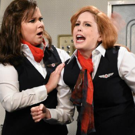 two women in uniform with red hair and black vests