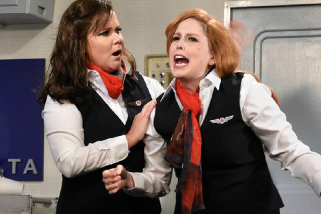 two women in uniform with red hair and black vests