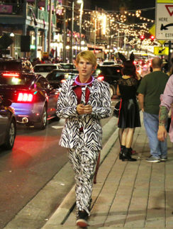 a man walking on a sidewalk in a garment