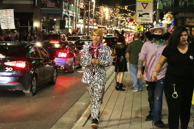 a man walking on a sidewalk in a garment