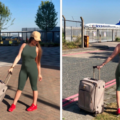 a woman in a green jumpsuit with a suitcase